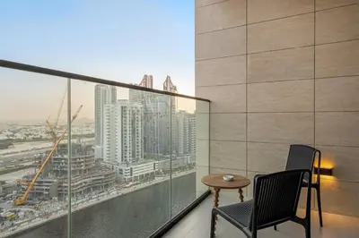 a balcony with two chairs and a table at FIRST CLASS Studio Private Jacuzzi Canal View in Dubai