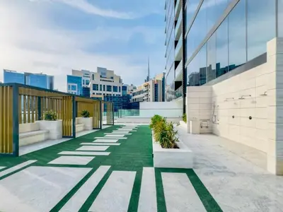 a courtyard in a building with grass and plants at FIRST CLASS Studio Private Jacuzzi Canal View in Dubai