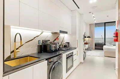 a kitchen with a sink and a washing machine at FIRST CLASS Studio Private Jacuzzi Canal View in Dubai