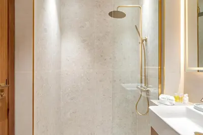 a shower with a glass door in a bathroom at FIRST CLASS Studio Private Jacuzzi Canal View in Dubai