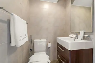 a bathroom with a white toilet and a sink at FIRST CLASS Villa Peaceful Pool View Retreat in Dubai