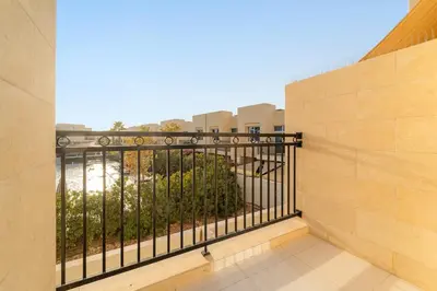 a balcony with a metal fence on a building at FIRST CLASS Villa Peaceful Pool View Retreat in Dubai