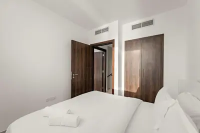 a bedroom with two white beds and a wooden door at FIRST CLASS Villa Peaceful Pool View Retreat in Dubai