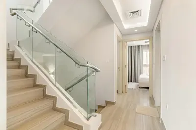 a staircase with glass railing in a house at FIRST CLASS VILLA Zen Luxe Contemporary Haven in Dubai