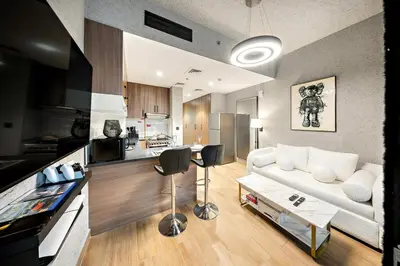 a living room with a white couch and a kitchen at FIRST CLASS 1BR Elegant Cozy Escape in Dubai