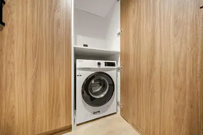 a washer and dryer in a small room at FIRST CLASS 1BR Elegant Cozy Escape in Dubai