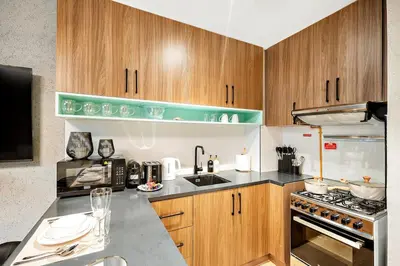 a kitchen with wooden cabinets and a stove top oven at FIRST CLASS 1BR Elegant Cozy Escape in Dubai