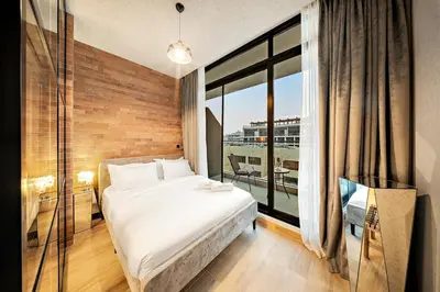 a bedroom with a bed and a large window at FIRST CLASS 1BR Elegant Cozy Escape in Dubai