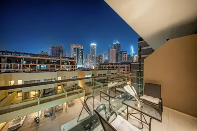 a balcony with a view of a city at night at FIRST CLASS 1BR Elegant Cozy Escape in Dubai