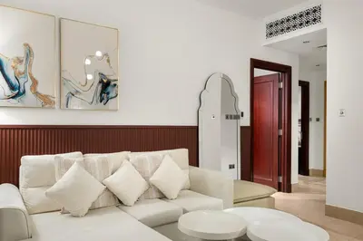 a living room with a white couch and a red door at FIRST CLASS 2BR Old Town Burj View Retreat in Dubai