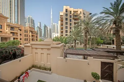 a view of a city with tall buildings and palm trees at FIRST CLASS 2BR Old Town Burj View Retreat in Dubai