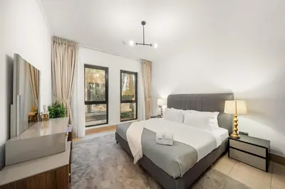 a bedroom with a bed and a desk and windows at FIRST CLASS 2BR Old Town Burj View Retreat in Dubai