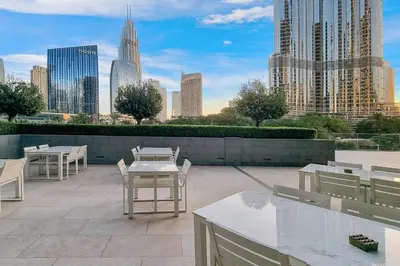 a patio with tables and chairs and a city skyline at FIRST CLASS 2BR Burj Khalifa & Fountain View in Dubai