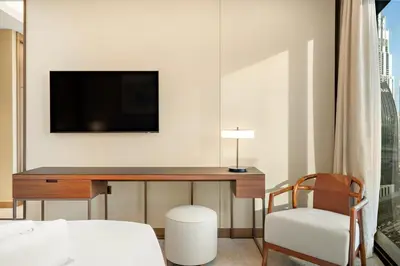 a bedroom with a desk with a tv and a chair at FIRST CLASS 2BR Burj Khalifa & Fountain View in Dubai
