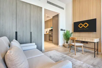 a living room with a couch and a table at Modern Studio at Oxford Gardens Arjan - Near Miracle Garden in Dubai