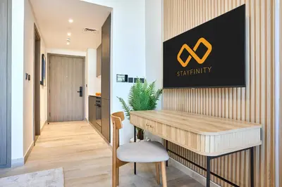 a office with a desk and a sign on the wall at Modern Studio at Oxford Gardens Arjan - Near Miracle Garden in Dubai