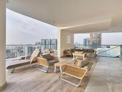 a living room with chairs and tables on a building at Modern Studio at Oxford Gardens Arjan - Near Miracle Garden in Dubai
