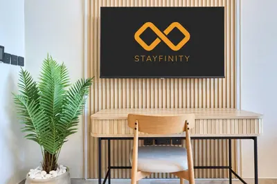 a desk with a chair and a picture of stay infinity at Modern Studio at Oxford Gardens Arjan - Near Miracle Garden in Dubai
