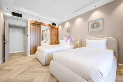 a bedroom with two beds and a chair at Amazing 2BR Princess Tower Dubai Marina in Dubai