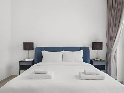 a white bed with two pillows and two lamps at Elegant 2BDR Full BurjKhalifa View In Downtown-06 in Dubai