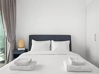 a bedroom with a white bed with two towels on it at Elegant 2BDR Full BurjKhalifa View In Downtown-06 in Dubai
