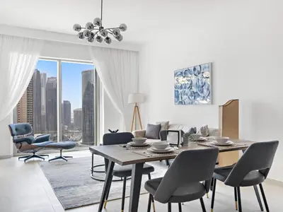 a living room with a dining room table and chairs at Elegant 2BDR Full BurjKhalifa View In Downtown-06 in Dubai