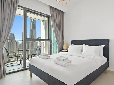 a bedroom with a bed and a large window at Elegant 2BDR Full BurjKhalifa View In Downtown-06 in Dubai
