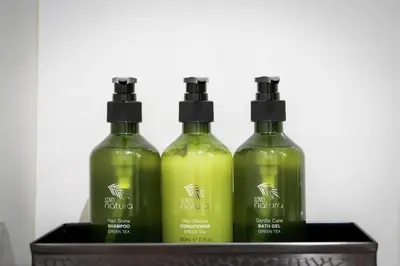 three bottles of green liquid in a black holder at Downtown Dubai Mall Walkable 8 min in Dubai