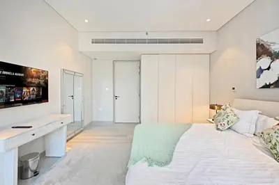 a white bedroom with a bed and a desk at Peaceful, Unique 1BR Experience ,Dubai Marina in Dubai