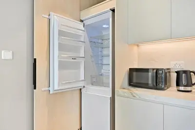 a microwave in an open refrigerator in a kitchen at Peaceful, Unique 1BR Experience ,Dubai Marina in Dubai