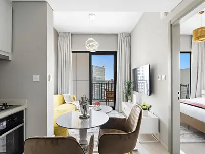a living room with a table and chairs and a bed at Premium 1 BDR in Zada Tower-Business Bay in Dubai