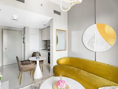 a living room with a yellow couch and a table at Premium 1 BDR in Zada Tower-Business Bay in Dubai