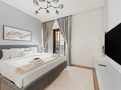 a bedroom with a large bed and a tv at Luxury Elegance 2BDR In Sunset-Creek Beach-03 in Dubai