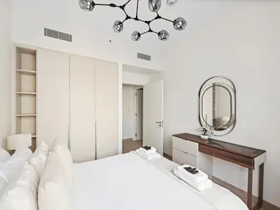 a white bedroom with a bed and a mirror at Luxury Elegance 2BDR In Sunset-Creek Beach-03 in Dubai