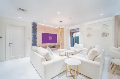 a living room with white furniture and a tv at Zaafaran 1- Luxury 2BR Apt Near Burj Khalifa & Dubai Mall in Dubai