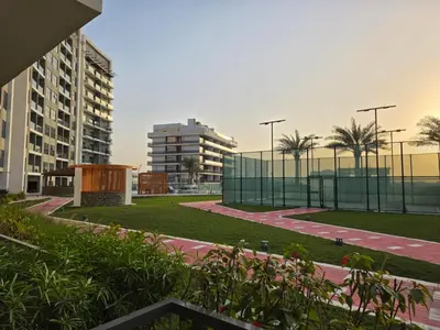 a park in a city with tall buildings at Wavez 06 Well Furnished Studio in Liwan in Dubai