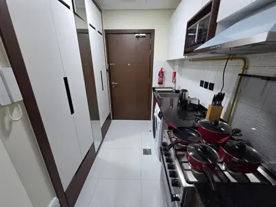 a kitchen with a stove with pots and pans at Wavez 06 Well Furnished Studio in Liwan in Dubai