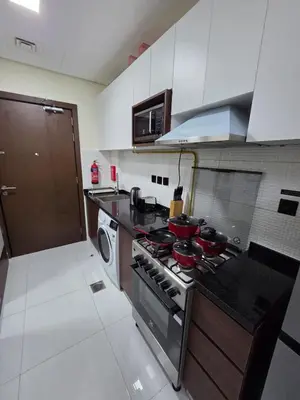 a kitchen with a stove with pots and pans on it at Wavez 06 Well Furnished Studio in Liwan in Dubai