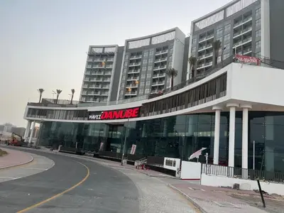 a large building with a sign that reads more ambulance at Wavez 06 Well Furnished Studio in Liwan in Dubai