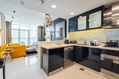a kitchen with black cabinets and a yellow couch at Ultra-Luxe Breathtaking Canal Views l Business Bay in Dubai