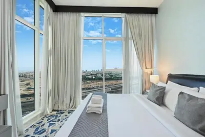 a bedroom with a large bed with a large window at Bayz by Denube in Dubai