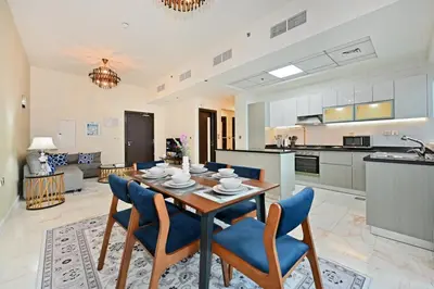 a kitchen and living room with a table and chairs at Bayz by Denube in Dubai