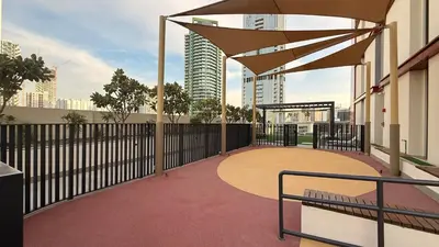 a balcony with a bench and an umbrella at Hadley Heights! Pool & Gym Access! 2 Double Bed, Balcony with a Great View! in Dubai