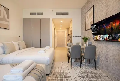 a hotel room with two beds and a dining room at Hadley Heights! Pool & Gym Access! 2 Double Bed, Balcony with a Great View! in Dubai