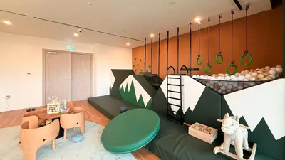 a living room with a green couch and a table at Hadley Heights! Pool & Gym Access! 2 Double Bed, Balcony with a Great View! in Dubai
