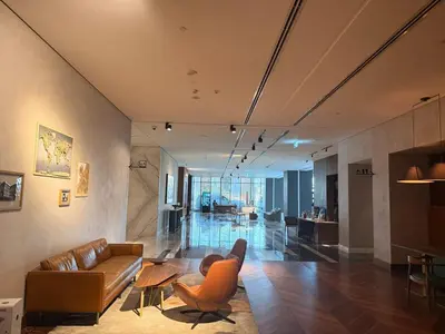 a living room with a couch and a chair at Novotel JVT Studio 5 Star Amenities Access in Dubai