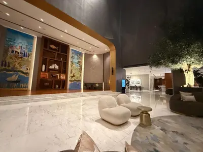 a large lobby with white chairs and a table at Novotel JVT Studio 5 Star Amenities Access in Dubai