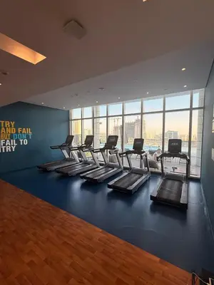a gym with a row of treadmills in a building at Novotel JVT Studio 5 Star Amenities Access in Dubai