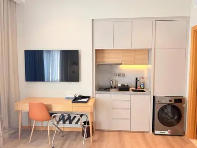a kitchen with a desk and a table and a dishwasher at Novotel JVT Studio 5 Star Amenities Access in Dubai