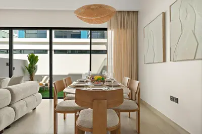 a dining room with a table and chairs and a couch at VayK - Modern 4 BD Townhouse with Private Garden in Damac Lagoons in Dubai